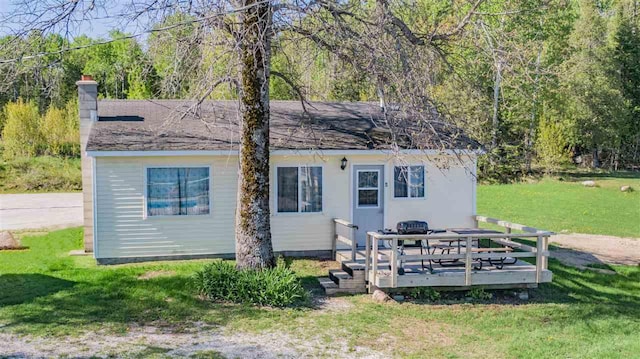 rear view of house with a deck and a lawn