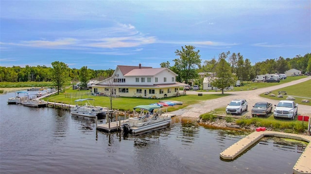 view of dock featuring a lawn and a water view