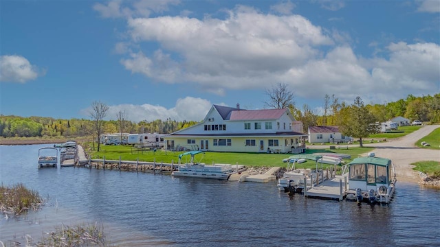 dock area with a water view and a yard