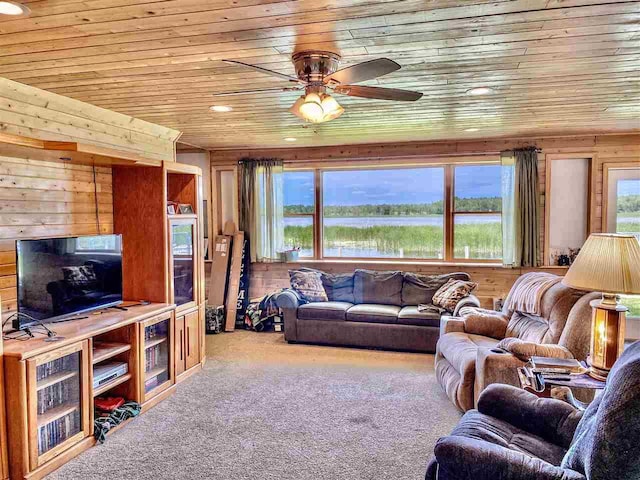 living room with wooden walls, wooden ceiling, a healthy amount of sunlight, and carpet flooring