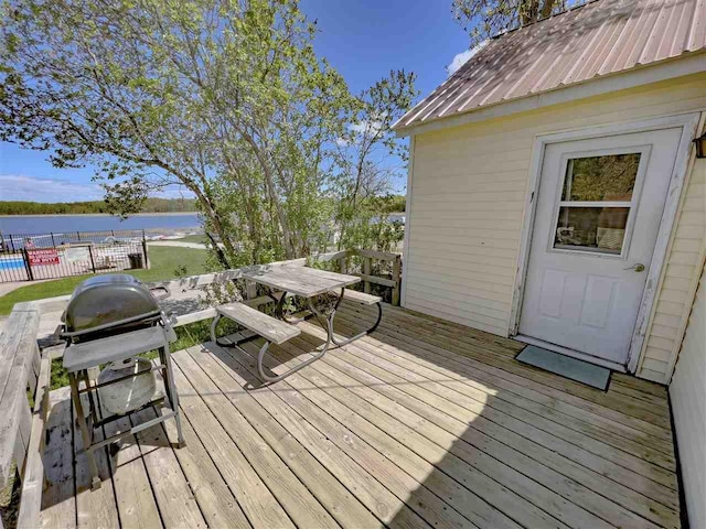 wooden terrace featuring a grill and a water view