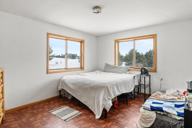 bedroom featuring multiple windows and dark parquet flooring