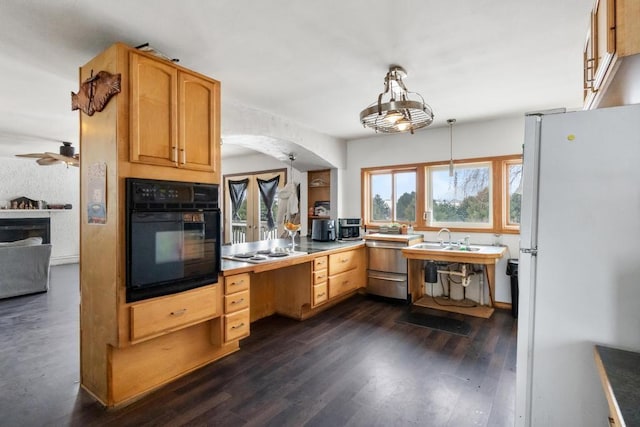 kitchen with sink, white appliances, dark hardwood / wood-style floors, light brown cabinetry, and decorative light fixtures