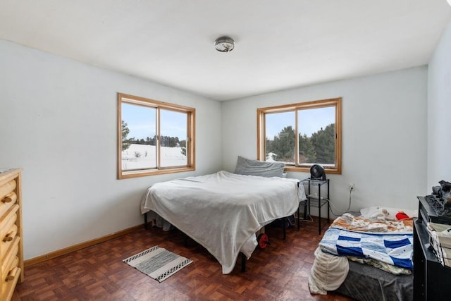 bedroom featuring multiple windows and dark parquet flooring