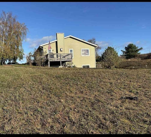 back of house with a lawn and a deck