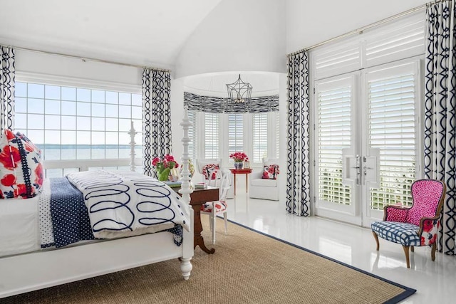 bedroom with multiple windows, access to exterior, vaulted ceiling, and a water view