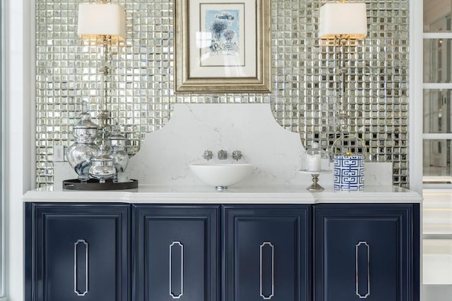 bar featuring blue cabinets and backsplash