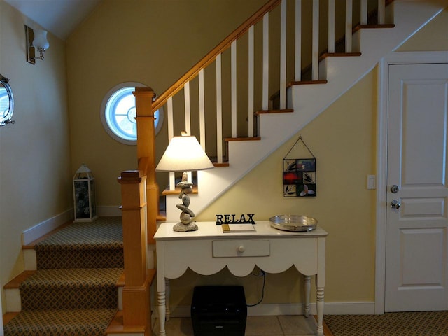 staircase featuring lofted ceiling and tile patterned flooring