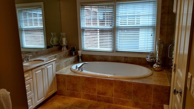 bathroom featuring a relaxing tiled tub, vanity, and tile patterned flooring