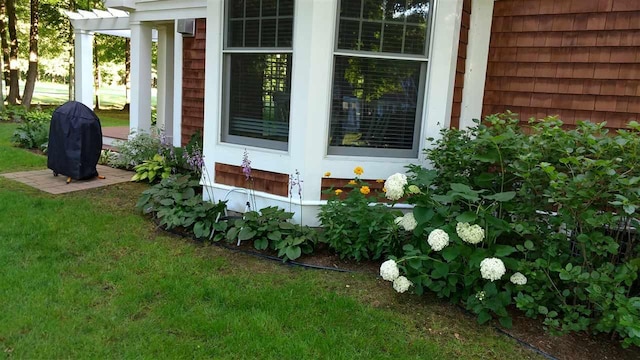 exterior space with a lawn and a pergola