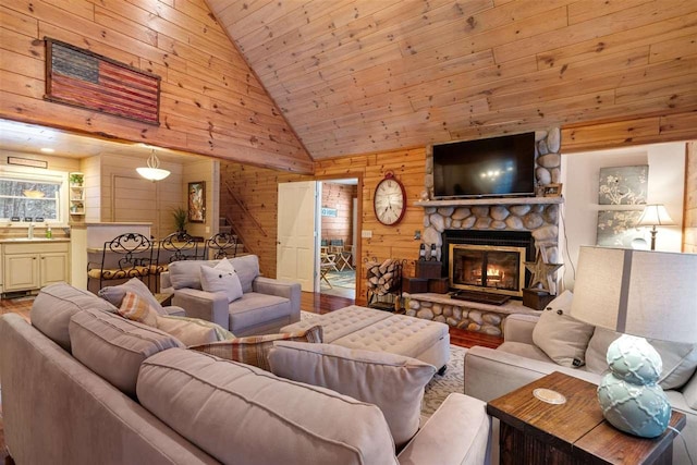 living room featuring a stone fireplace, wood walls, wood-type flooring, sink, and wooden ceiling