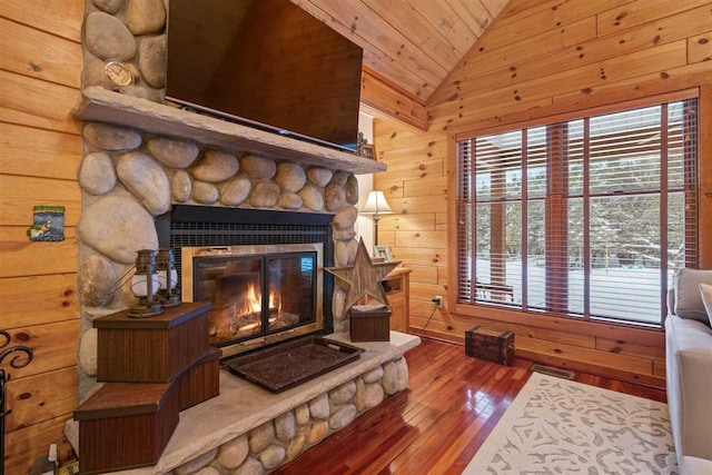 interior space featuring wood ceiling, wood-type flooring, a fireplace, and wood walls