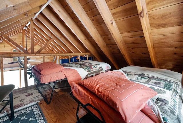 bedroom with hardwood / wood-style flooring, vaulted ceiling, and wooden walls