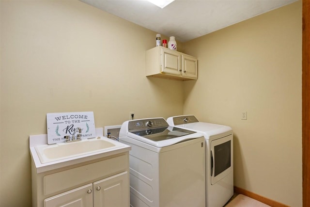 laundry area featuring cabinets, washing machine and clothes dryer, and sink