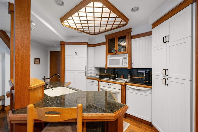 kitchen featuring sink, white appliances, light hardwood / wood-style flooring, and white cabinets