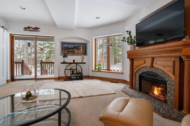 living room with a fireplace and carpet