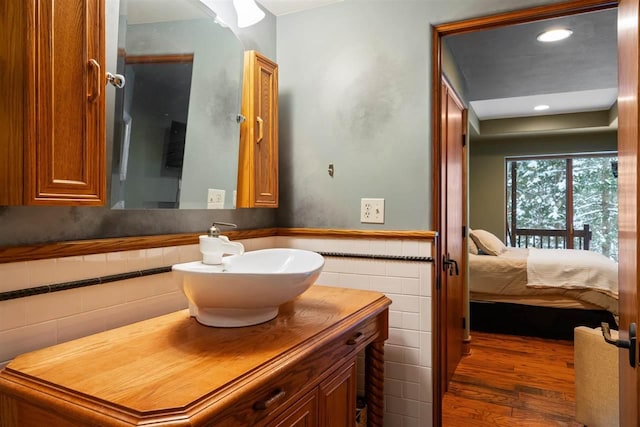 bathroom featuring hardwood / wood-style flooring, vanity, and tile walls