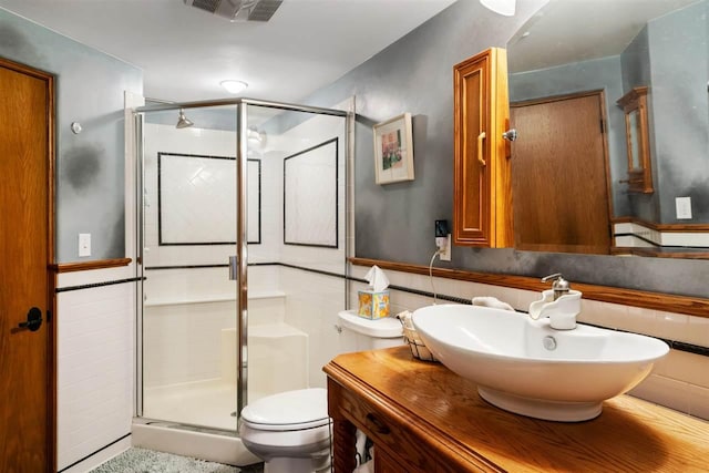 bathroom featuring vanity, toilet, and a shower with shower door