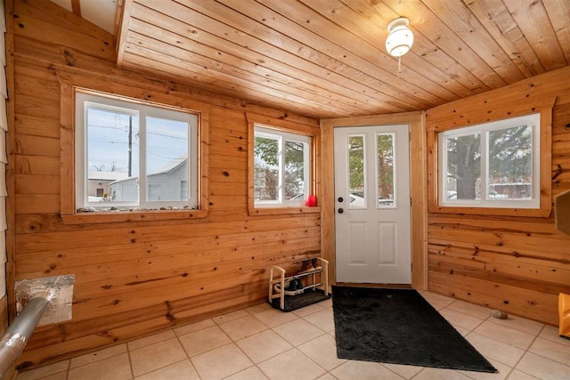 entryway with light tile patterned flooring, wooden walls, and wooden ceiling