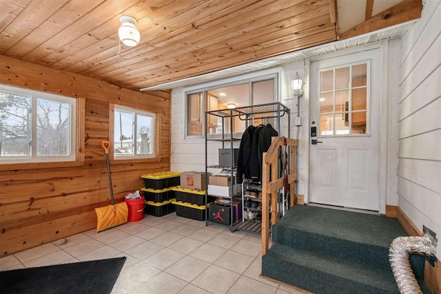 interior space with wood walls, light tile patterned floors, and wooden ceiling