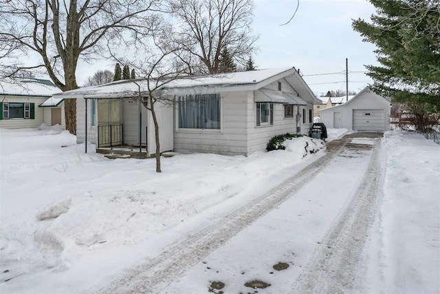 bungalow-style home featuring a garage and an outdoor structure