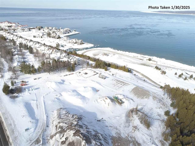 snowy aerial view featuring a water view