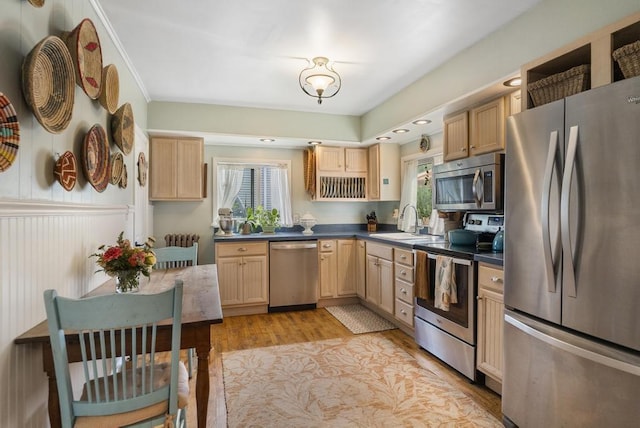 kitchen featuring sink, light brown cabinets, ornamental molding, stainless steel appliances, and light hardwood / wood-style floors