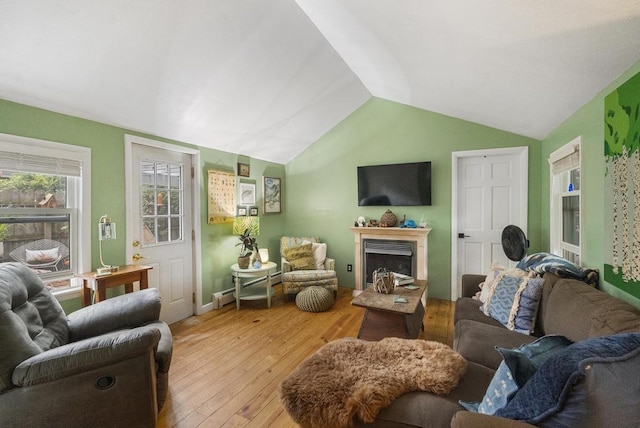 living room with vaulted ceiling, a baseboard radiator, and light hardwood / wood-style flooring