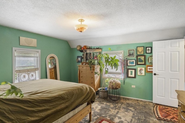 bedroom featuring lofted ceiling and a textured ceiling