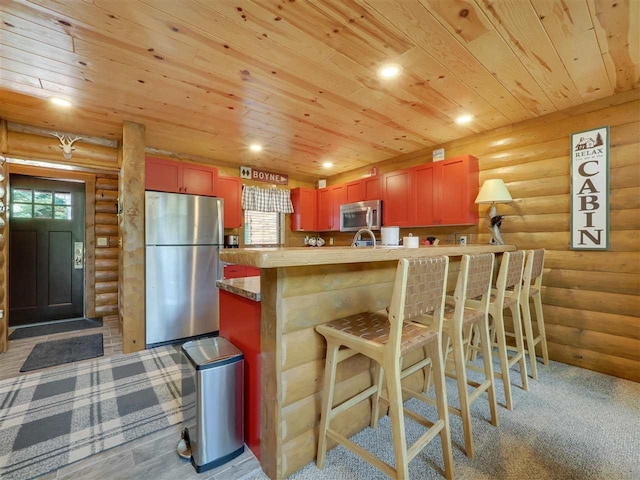 kitchen with butcher block countertops, wood ceiling, plenty of natural light, a kitchen breakfast bar, and stainless steel appliances