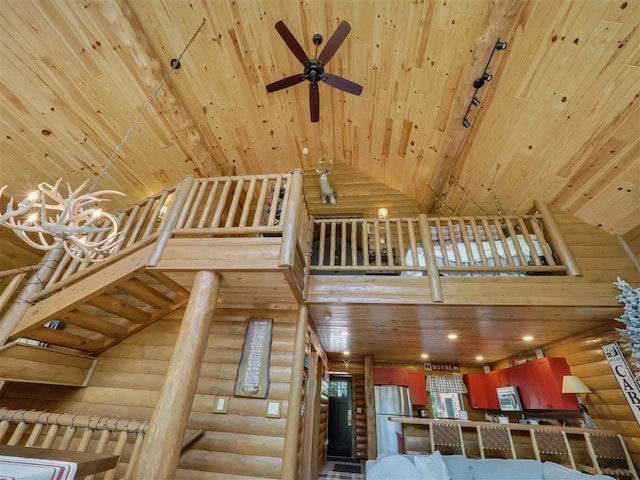 unfurnished living room with ceiling fan, log walls, high vaulted ceiling, and wooden ceiling