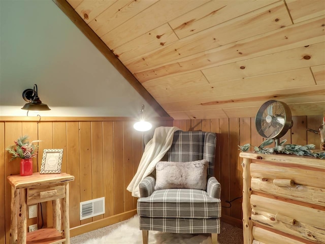 sitting room with wood ceiling, vaulted ceiling, carpet, and wood walls