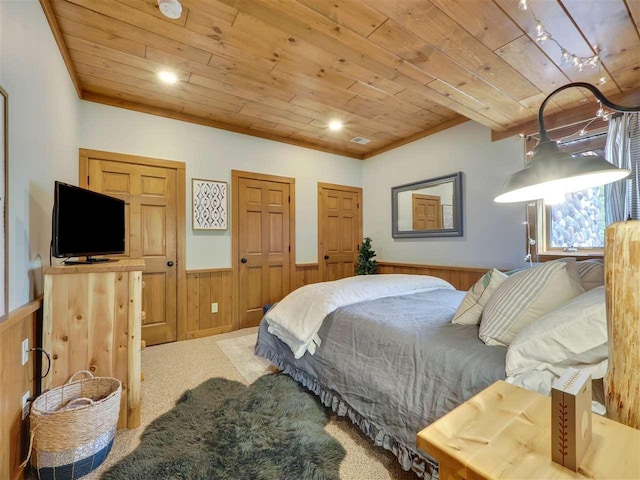 carpeted bedroom with crown molding, two closets, wooden walls, and wooden ceiling