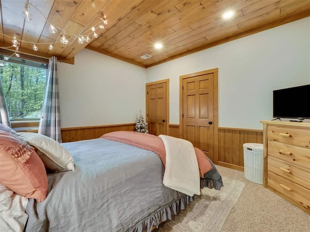 bedroom featuring carpet floors, wooden ceiling, rail lighting, and wood walls