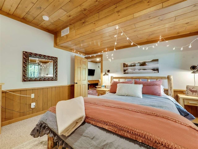 bedroom featuring wooden walls, wood ceiling, and carpet flooring