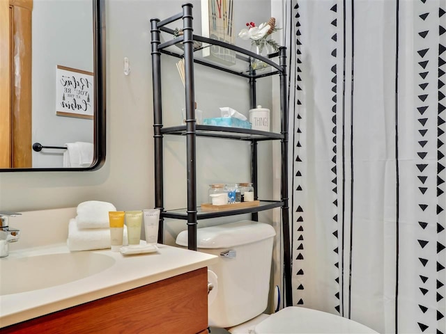 bathroom featuring walk in shower, vanity, and toilet