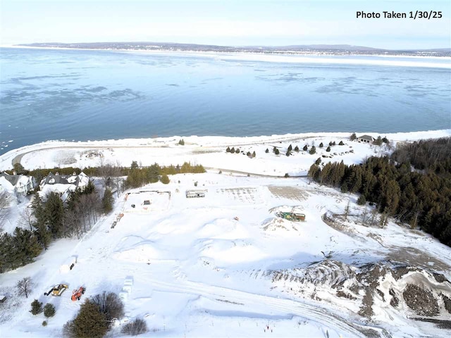 snowy aerial view featuring a water view