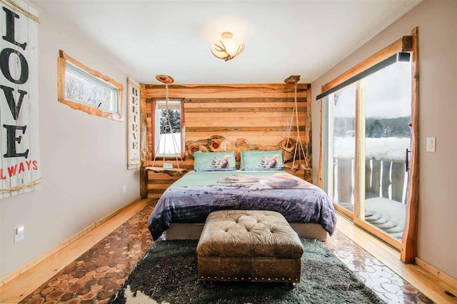 bedroom featuring wooden walls, wood-type flooring, and access to exterior