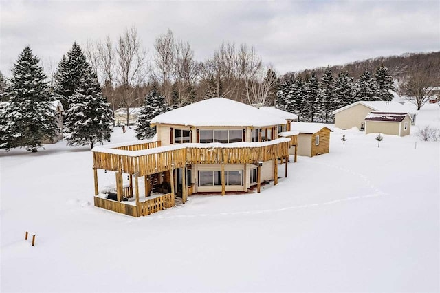 snow covered property with a wooden deck