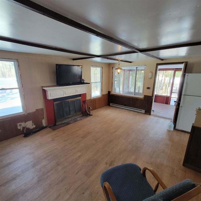 living room featuring beam ceiling, plenty of natural light, a baseboard heating unit, and light hardwood / wood-style floors