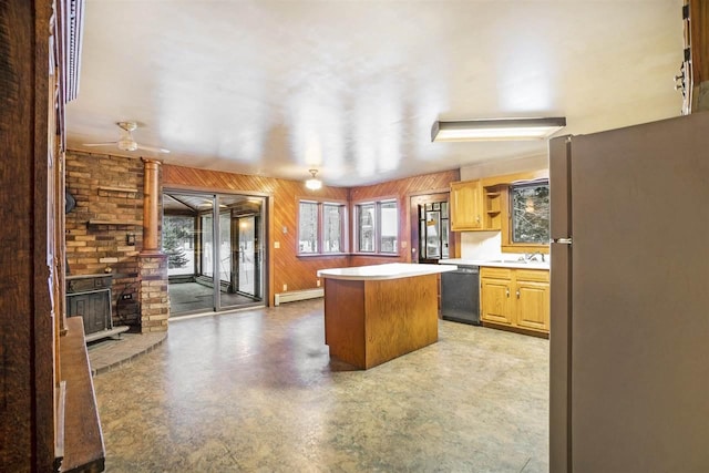 kitchen featuring sink, wooden walls, fridge, and black dishwasher