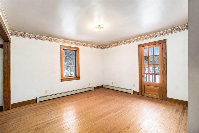 empty room featuring a baseboard radiator and light hardwood / wood-style floors