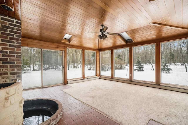 unfurnished sunroom with lofted ceiling with skylight, a healthy amount of sunlight, wooden ceiling, and ceiling fan