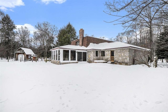 snow covered property featuring a sunroom