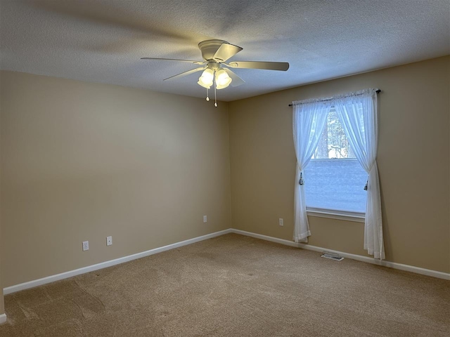 carpeted empty room with ceiling fan and a textured ceiling