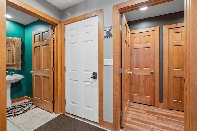 corridor featuring sink and light tile patterned floors