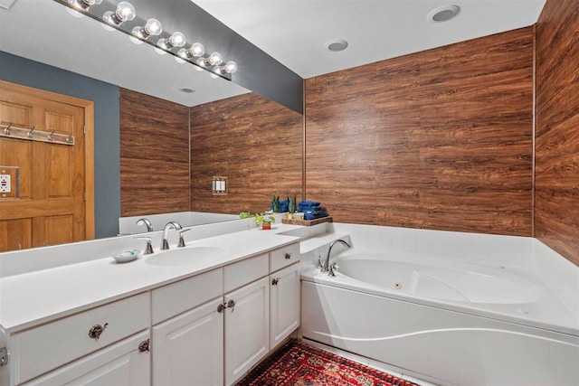 bathroom featuring vanity, a bathtub, and wood walls