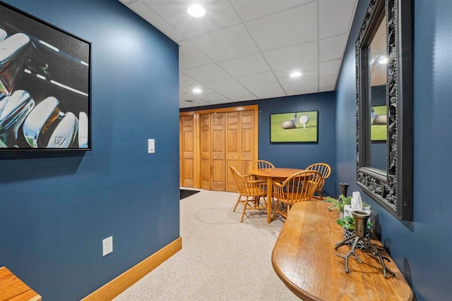 carpeted dining room featuring a drop ceiling