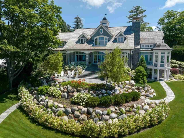 rear view of property featuring a lawn