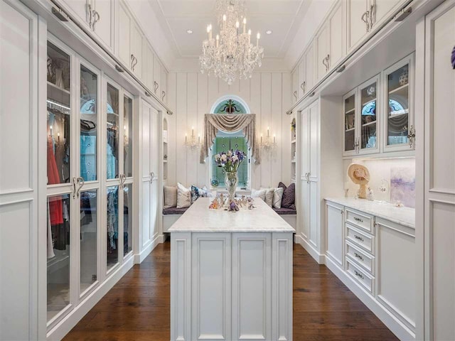 kitchen with crown molding, a center island, white cabinets, and decorative light fixtures